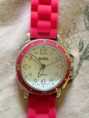 Pink Bora watch with white face and silver accents
